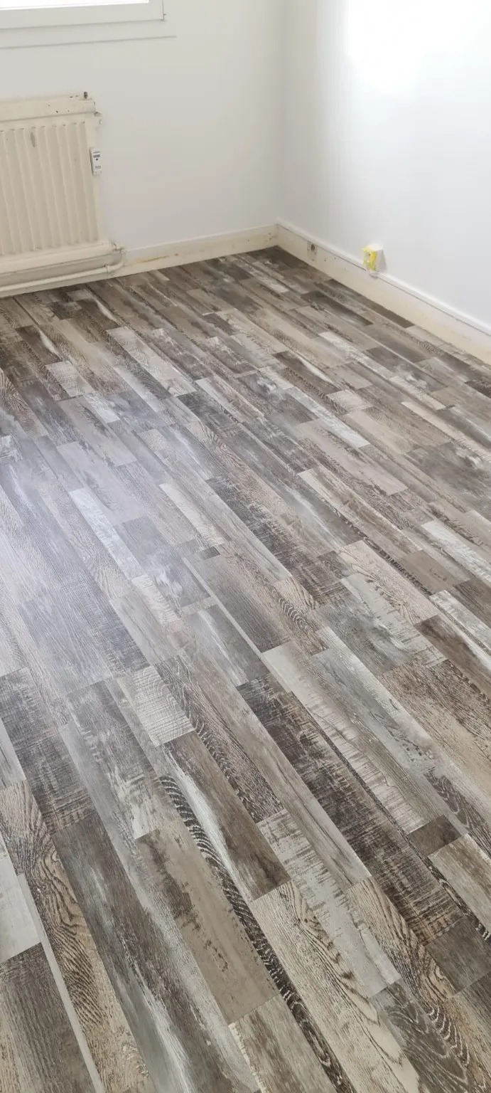 Parquet stratifié effet bois vieilli posé par Rocher Renove