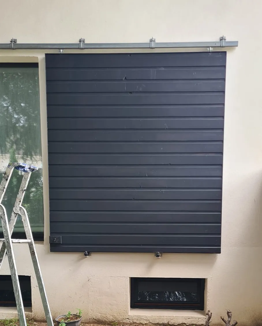 Volet repeint en gris anthracite sur une façade claire