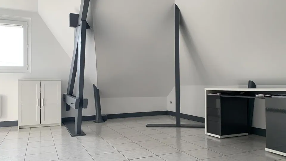 Combles aménagés : murs blancs et poutres anthracite