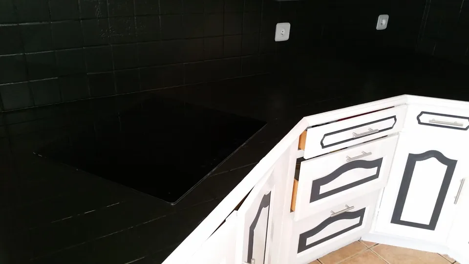 Crédence carrelée noire et façades de cuisine blanches